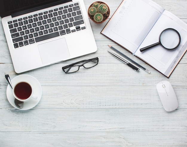 Modern workplace on wooden table with a lot of things on it