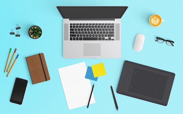 Modern workspace with coffee cup, notebook, smartphone and laptop on Blue color