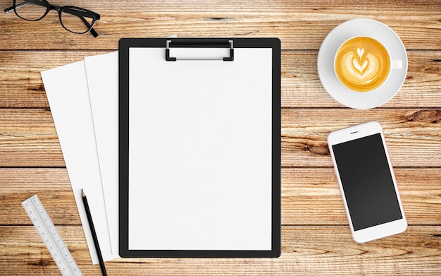 Modern workspace with coffee cup, paper, notebook, tablet or smartphone and clipboard on wood