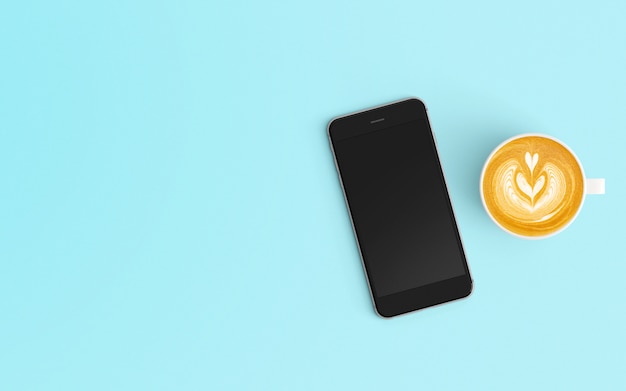 Area di lavoro moderna con tazza di caffè e smartphone sul colore blu