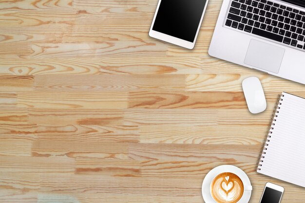 Modern workspace with laptop tablet smartphone and coffee cup copy space on wood background