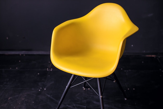 黒い部屋のインテリア寄木細工の床のモダンな黄色の椅子。