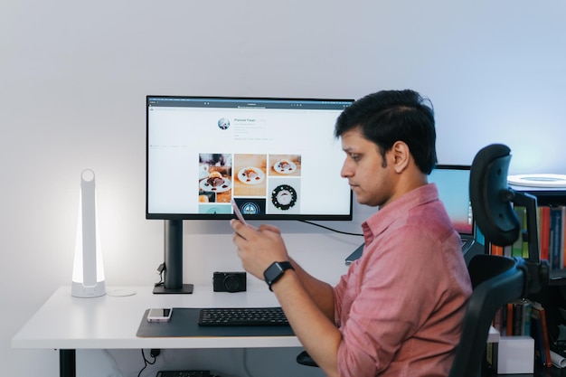 modern young handsome man in casual outfit sitting at table working on laptop