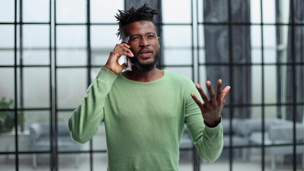 Modern young man with mobile phone in the office