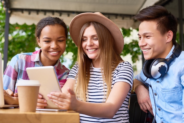 Giovani moderni che utilizzano i dispositivi del computer nel caffè