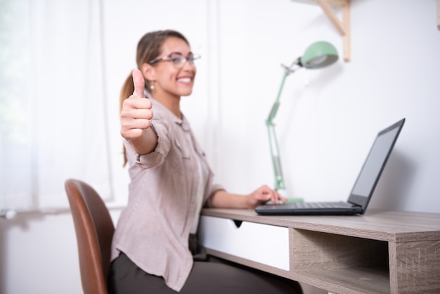 Photo modern young woman showing thumbs up