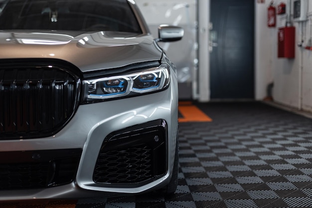 Moderne auto met motorkap is bij het servicestation en het detailcentrum Bescherming en verzorging van de auto Controle en reparatie van de auto