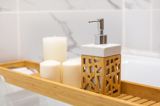 Moderne badkamer met houten tafel en kaarsen. wit marmeren achtergrondmuur zijaanzicht