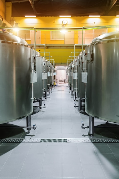 Moderne bierfabriek. Rijen stalen tanks voor de opslag en fermentatie van bier. Zonlichteffect