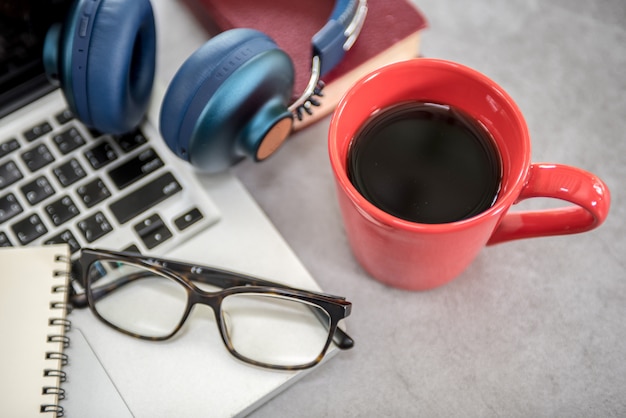 Moderne bureautafel met laptop, smartphone en andere benodigdheden met een kopje koffie.