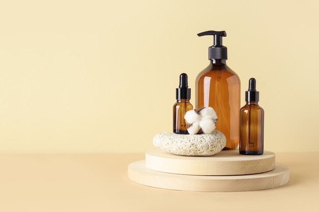 Moderne compositie met natuurlijke cosmetica en etherische olie met spa-set van donkere barnsteenflessen