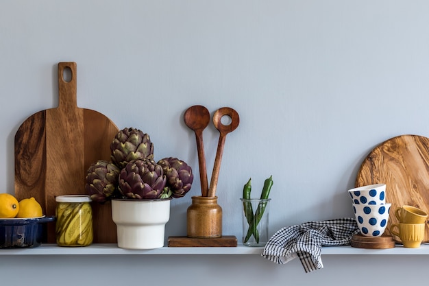 Moderne compositie op het keukeninterieur met groenten snijplank, voedsel, kruiden, keukenaccessoires en kopie ruimte op de plank.