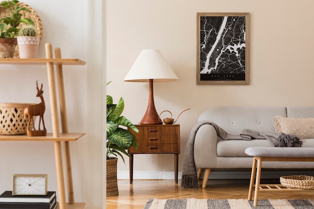 Moderne compositie van woonkamerinterieur met bruin frame, design retro commode, bank, boekenstandaard, rotan mand met plant en elegante accessoires. stijlvolle thuisopvoering.