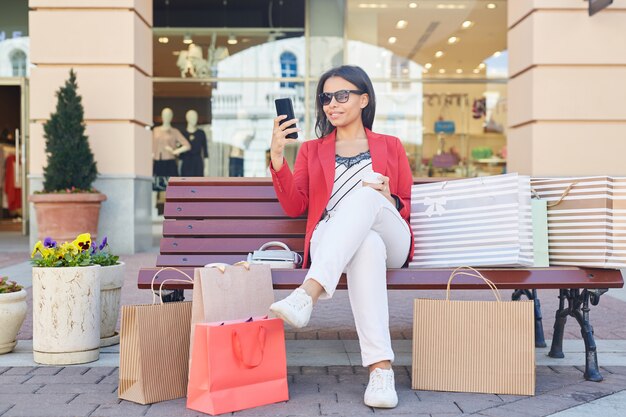 Moderne dame die gadget buiten gebruikt