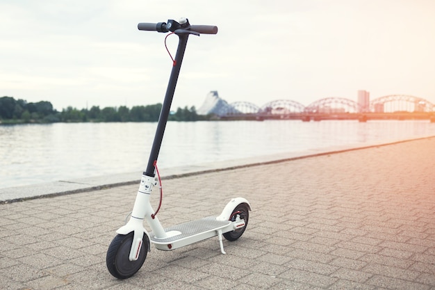 Moderne elektrische scooter aan de rivieroever van de stad