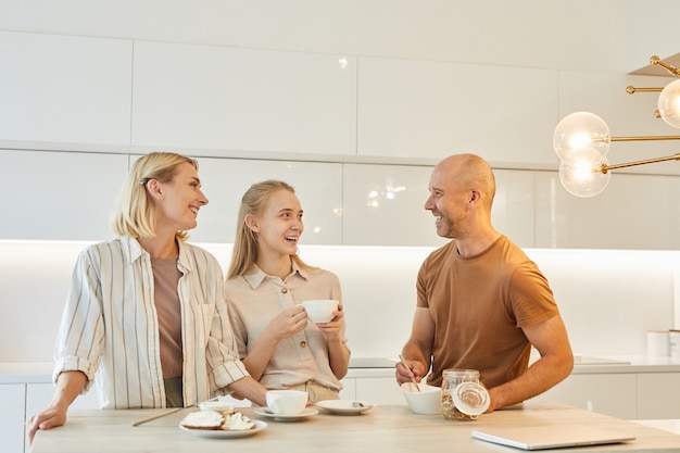 moderne en gelukkige familie genieten van ontbijt samen terwijl je aan tafel in keuken interieur