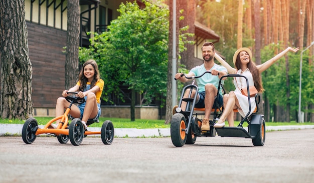 Moderne gelukkige jonge toeristische familie op vakantie rijden op fietsen en samen plezier hebben