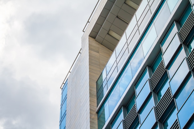 Moderne glazen gebouw wolkenkrabbers met bewolkte hemel reflectie