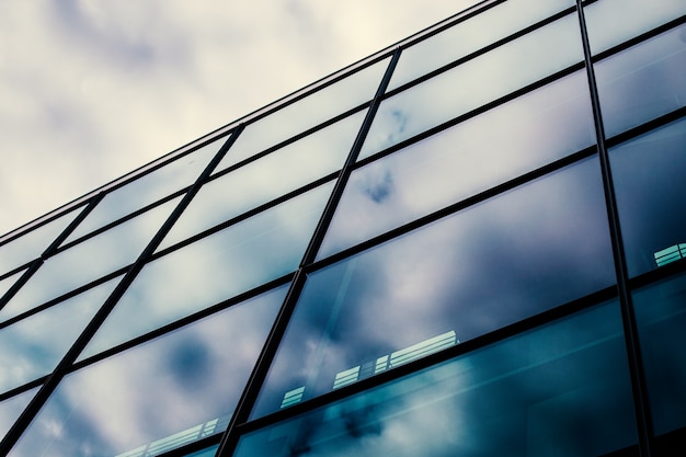 Moderne glazen gevel van een kantoorgebouw, weerspiegeling van de lucht in de windows.