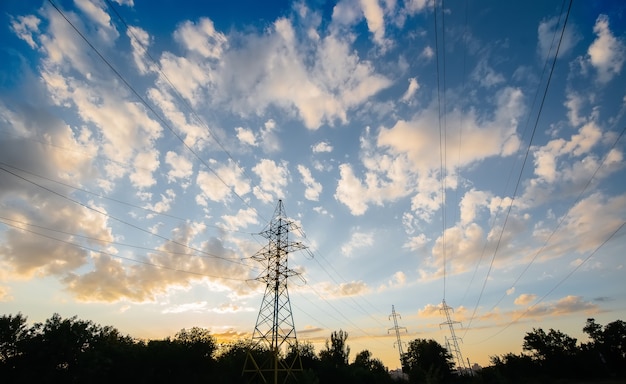 Moderne hoogspanningslijnen bij zonsondergang. Energie.