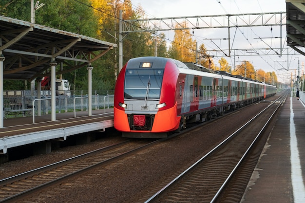 Moderne intercity hogesnelheidstrein bij zonsondergang commercieel voorstedelijk spoorwegvervoer concept