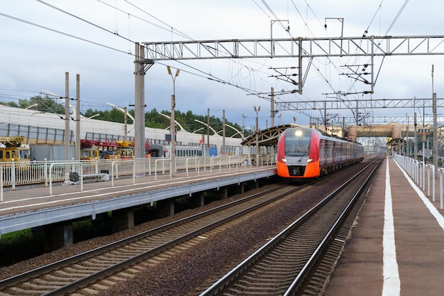 Moderne intercity hogesnelheidstrein bij zonsondergang commercieel voorstedelijk spoorwegvervoer concept