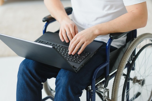 Moderne jonge gehandicapte man in rolstoel met videogesprek