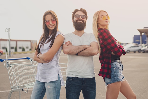 Foto moderne jonge mensen staan samen op de parkeerplaats van de supermarkt