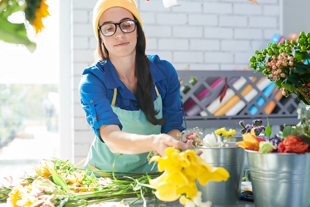 Moderne Jonge Vrouw die Bloemen schikken