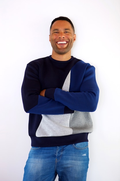 Moderne jonge zwarte mens die met wapens glimlacht die op witte achtergrond worden gekruist