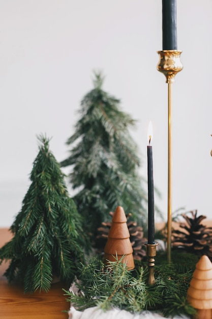 Moderne kersttafel met miniatuurkerstbomen, kaarsen en dennenappelversieringen