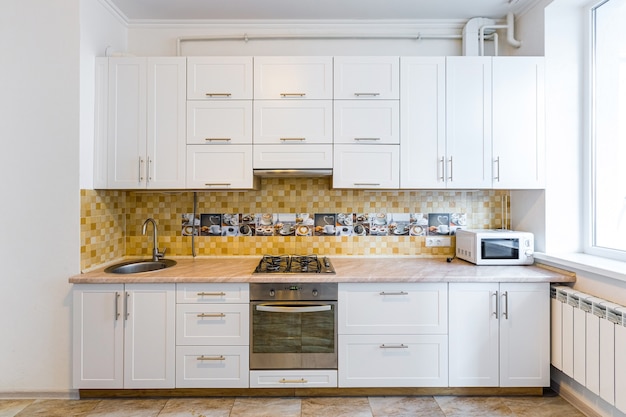 moderne keuken in lichte witte tinten met zwarte marmeren tegels