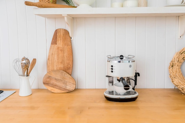 Moderne koffiemachine met kop op aanrecht in keuken