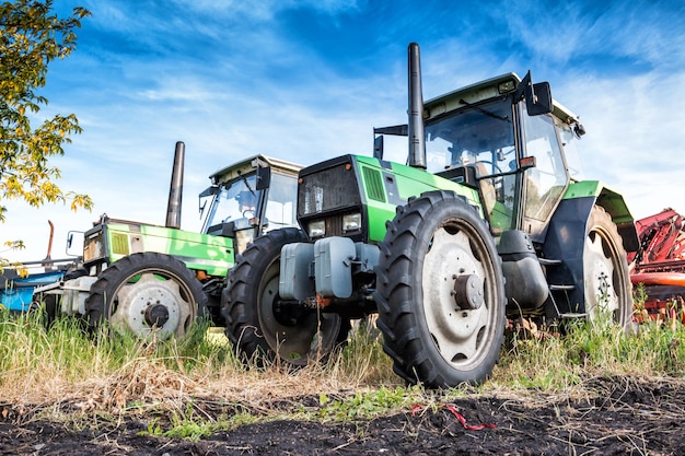 Moderne landbouwtractoren op wielen met oogstapparatuur op een veld