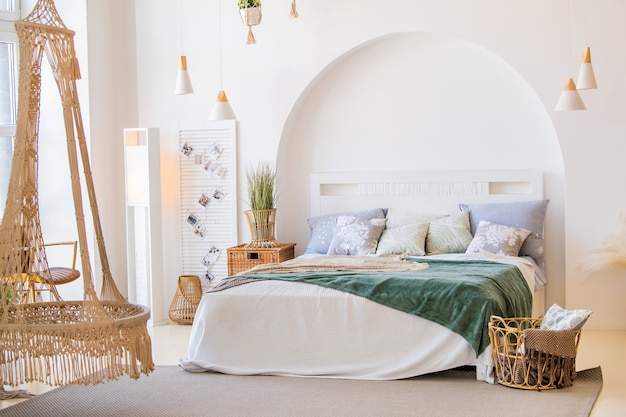 Foto moderne lichte slaapkamer interieur met bed, kussens en kamerplanten en decoratieve manden