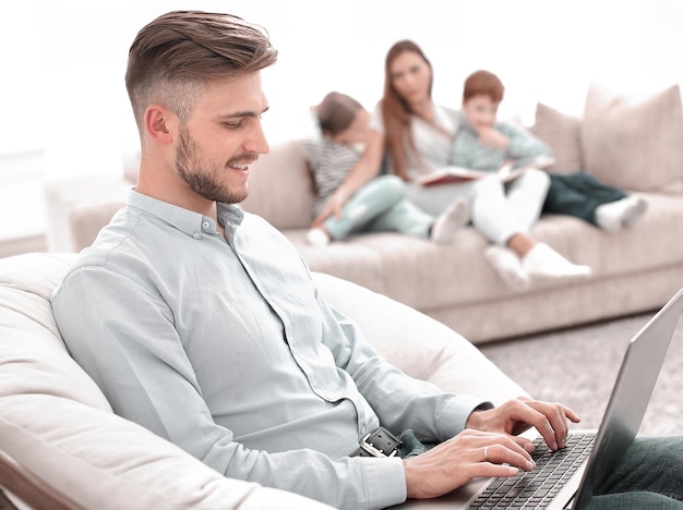 Moderne man aan het werk met laptop in zijn woonkamer