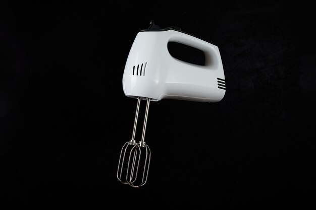 Moderne mixer of handmixer voor keuken koken geïsoleerd op donkere achtergrond.