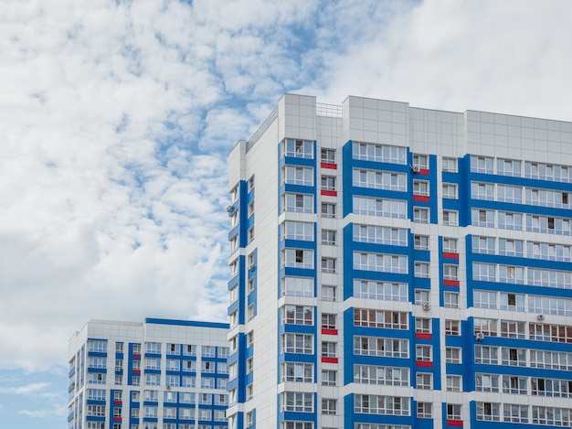 Moderne mooie nieuwe hoogbouw woongebouwen. Gekleurde muur op de achtergrond van blauwe lucht. Ruimte kopiëren.