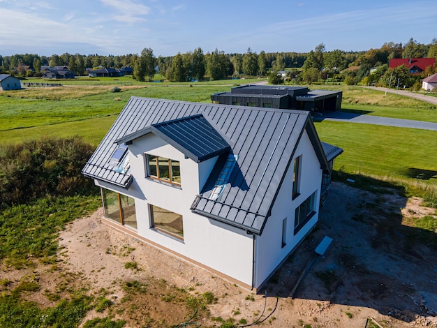 Moderne nieuw gebouwde woning met een metalen dak en grote ramen op het platteland