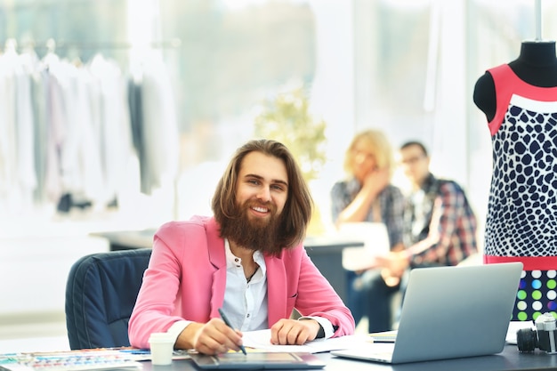 Moderne ontwerper en zijn team kiezen de stof voor kleding in een creatieve studio