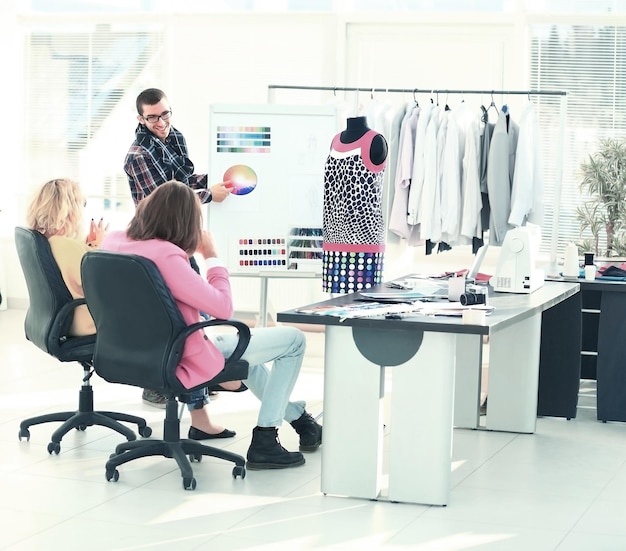 Moderne ontwerper en zijn team kiezen de stof voor kleding op kantoor