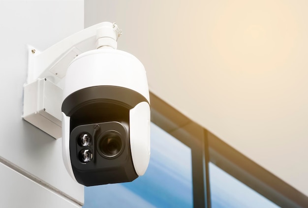 Moderne openbare CCTV-camera op de muur buiten het gebouw met kopieerruimte