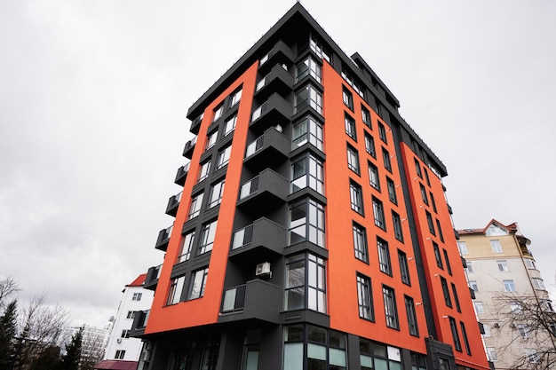 Moderne oranje residentiële flatgebouwen met meerdere verdiepingen Gevel van nieuwe huizen