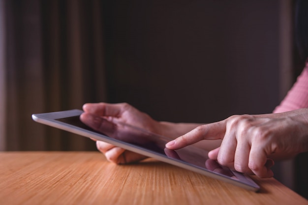 Moderne persoon met behulp van digitale Tablet op houten tafel