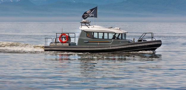 Moderne piraten op een motorboot in een baai onder piratenvlag