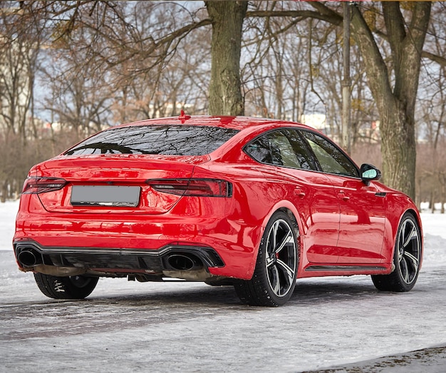 Foto moderne rode sportwagen in het de winter bos achtergrondautobehang