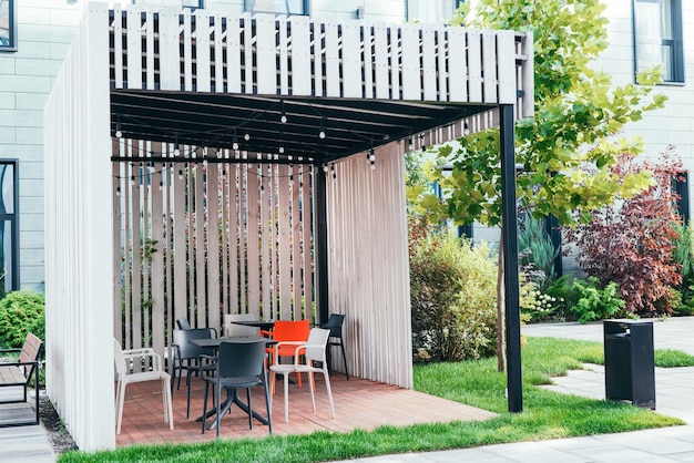 Moderne rookzone buiten bedrijfsgebouw houten tuinhuisje met stoelen Groene zone