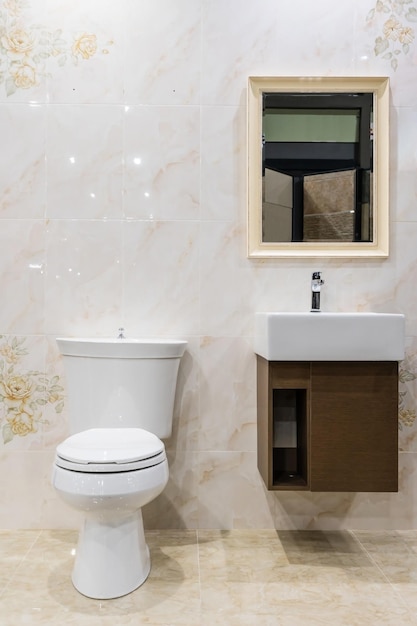 Moderne ruime badkamer met heldere tegels met toilet en gootsteen