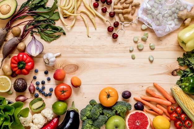 Moderne samenstelling van verse gezonde groenten en fruit op de houten tafel in de keuken. Vegetarische veganistische achtergrond. Zero waste. Bovenaanzicht. Ruimte kopiëren.