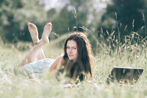 Moderne schattig meisje relaxarea op het verse gras. mensen en technologie